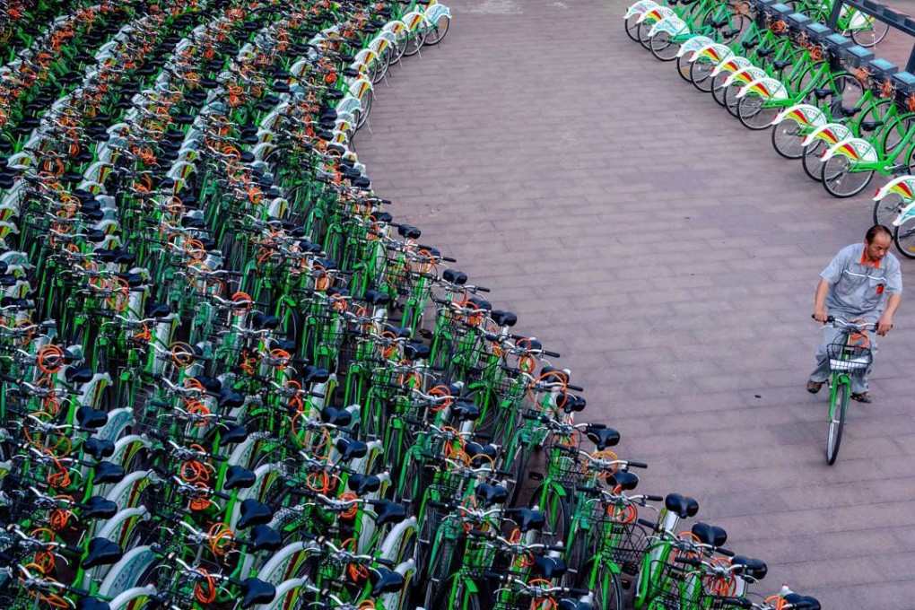A file picture taken three years ago of a man riding through a bicycle-sharing station in Beijing. Photo: AFP