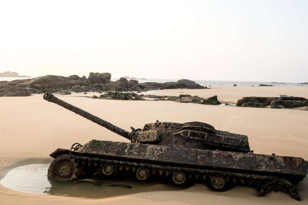 A tank half buried in the sand on a beach in Kinmen emerges from the ground at low tide. Photo: Sim Chi Yin / VII