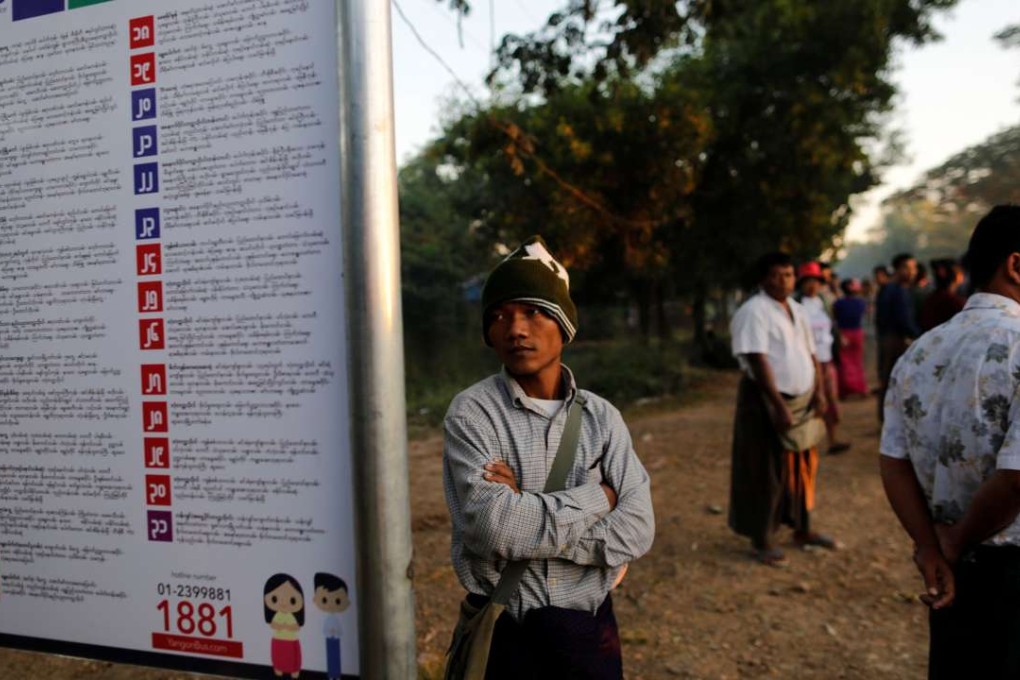 A man looks at a sign showing the bus routes for a new transport system at a bus stop in Yangon. Photo: Reuters