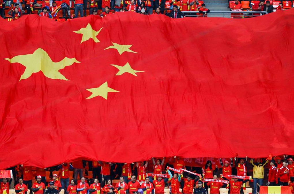 Fans hold a China flag at the match between China and Croatia in the China Cup at the weekend. REUTERS