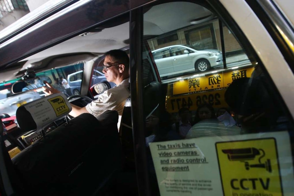 A rear window sticker declares the presence of closed-circuit TV cameras and radio equipment in a taxi in Ho Man Tin last September. The Association of Taxi Industry Development says it aims to raise service quality with the installation of on-board surveillance cameras. Photo: David Wong