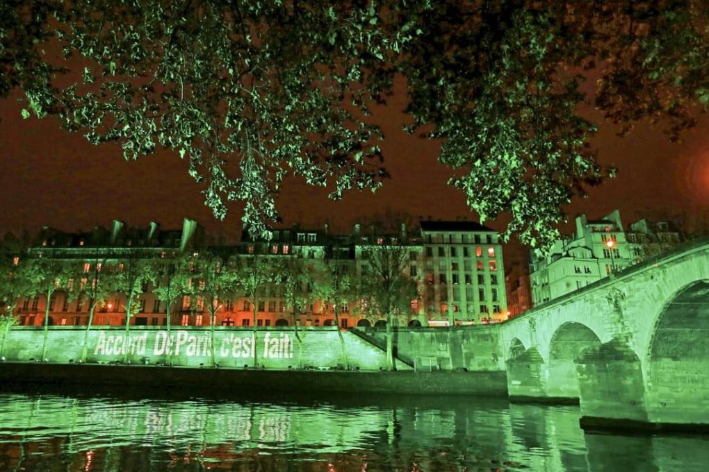 The banks of the Seine river in Paris are illuminated in green with the words Paris Agreement is Done, to celebrate the COP21 Climate Change agreement on November 4, 2016. Photo: Reuters
