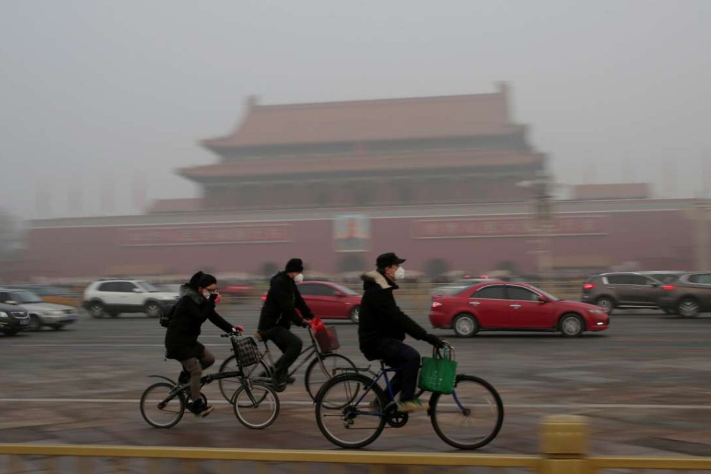 People wear masks to protect themselves from the smog as they cycle in Beijing. Photo: Reuters