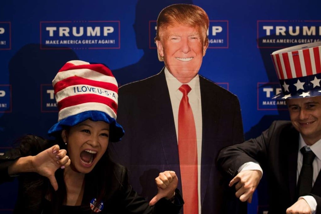 A couple pose for a picture next to a cardboard cut-out of then US presidential candidate Donald Trump during an election event organised by the American consulate in Shanghai last November 9. Photo: AFP