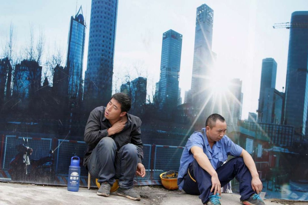 Workers rest outside a construction site in Beijing's central business district. Photo: Reuters