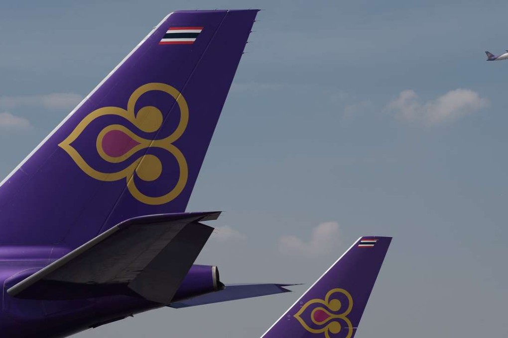 (FILES) This file photo taken on November 24, 2014 shows a Thai Airways aircraft taking off past the tails of two other Thai Airways planes at Bangkok's Suvarnabhumi international aiport. Thailand's flagship airline on January 19, 2017 said it had launched a probe into revelations that Rolls-Royce paid millions of dollars in bribes to win contracts, including to airline employees and government officials. / AFP PHOTO / CHRISTOPHE ARCHAMBAULT