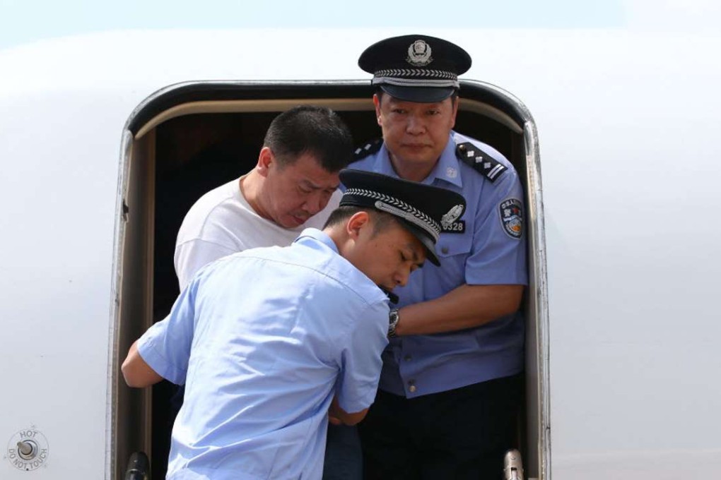 Police escort repatriated businessman Yang Jinjun off his flight from the US in 2015, as part of Beijing’s anti-corruption drive. Photo: Xinhua