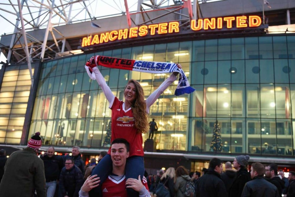 Fans pose for photographs in front of Old Trafford stadium. Manchester United have regained top spot in the global soccer rich list. Photo: AFP