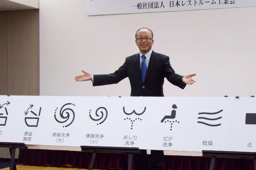 Madoka Kitamura, chairman of the Japan Sanitary Equipment Industry, with the new symbols. Photo: AFP