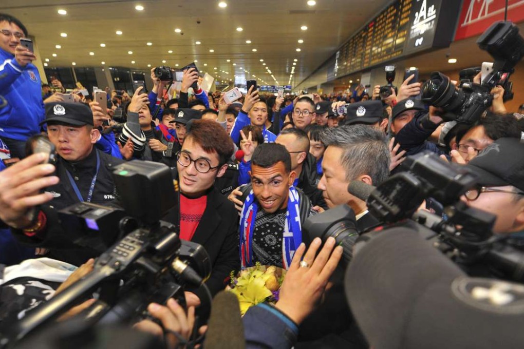 Carlos Tevez is mobbed at Shanghai’s Pudong airport as he arrives to start collecting a weekly wage reported to be US$800,000. Photo: AP