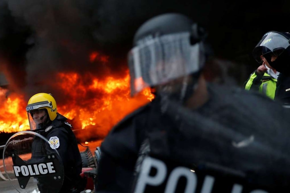 Firefighters arrive as police stand guard in front of a limousine which was set ablaze in Washington, DC. Photo: Reuters