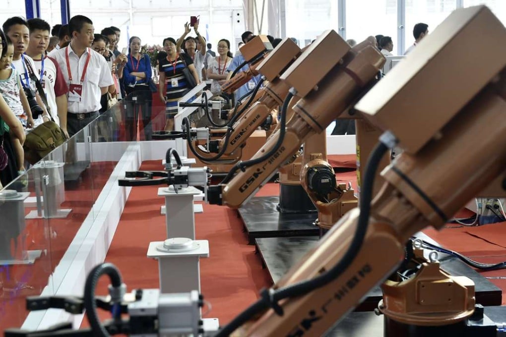 Visitors look at an industrial robot displayed at China International Internet Plus Exposition in Foshan. Photo: Xinhua