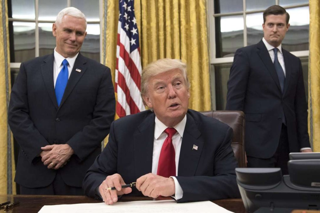 US President Donald Trump (centre) sits in the Oval Office at the White House after his inauguration on Friday. Photo: EPA