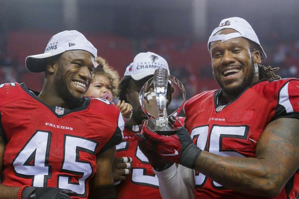 Atlanta Falcons linebacker Deion Jones (left) and Atlanta Falcons defensive tackle Jonathan Babineaux hold the NFC Championship Trophy after the Falcons defeated the Green Bay Packers in the NFC Championship game. Photo: EPA