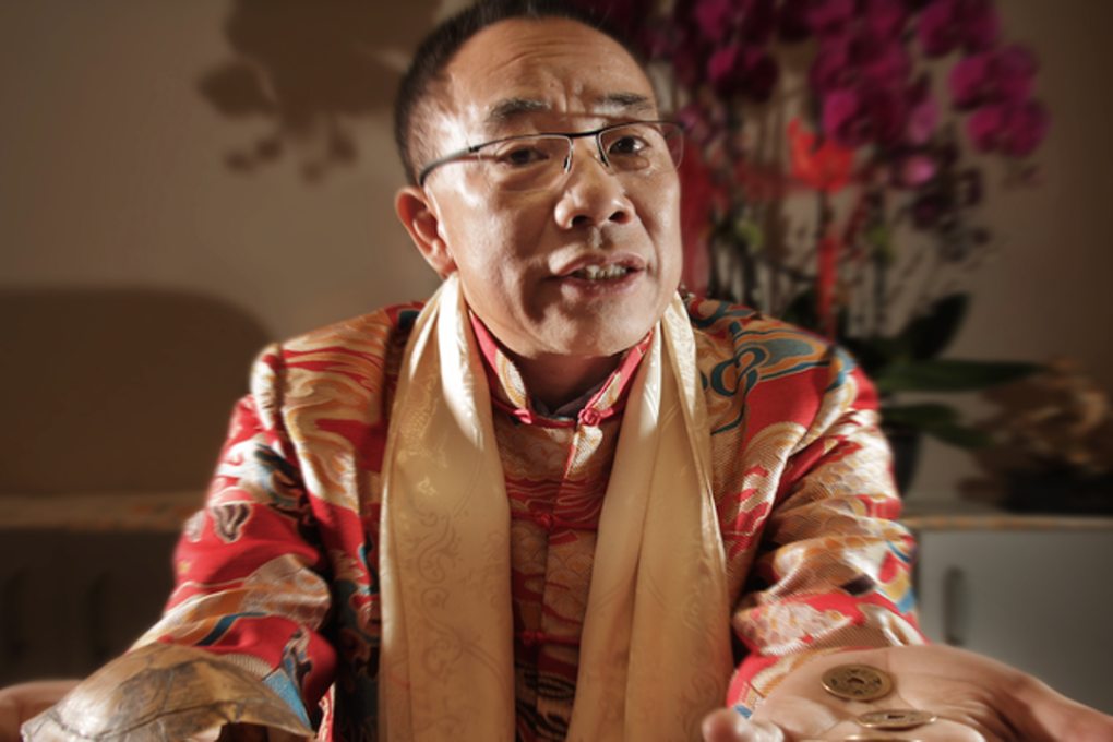 Richmond astrologer and fortune teller Sherman Tai with coins and turtle shell; the coins are shaken inside the shell, then rolled onto a table like dice to start the forecasting process. Photo: Rob Kruyt