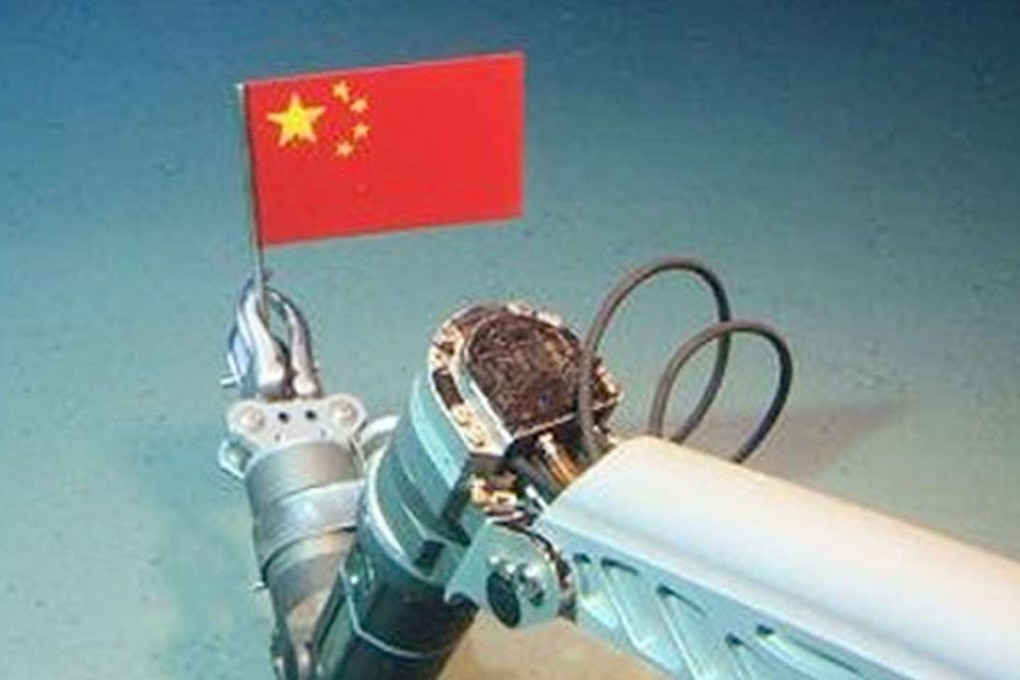 A robotic arm from the Jiaolong (sea dragon) submersible places a Chinese national flag on the seabed. Photo: Xinhua