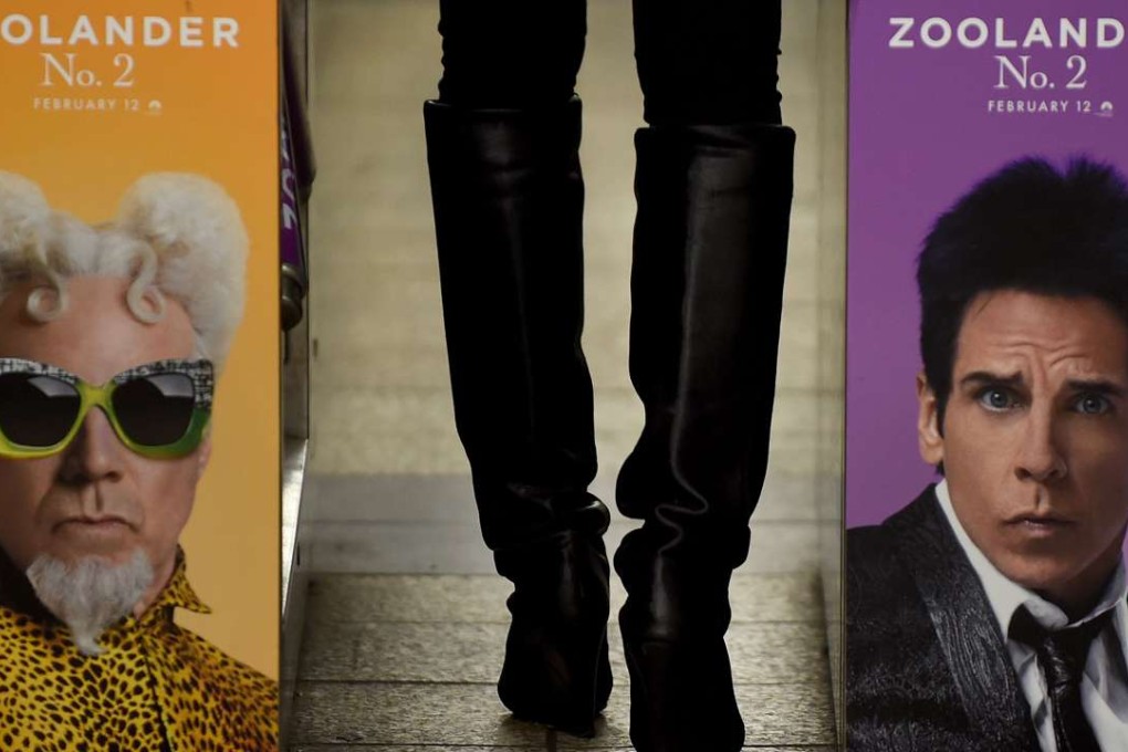 This file photo taken on February 25, 2016 shows a woman passing through a turnstile in the New York City Subway with a advertisement for Zoolander No 2 featuring Ben Stiller (right) and Will Ferrell. "Photo: AFP