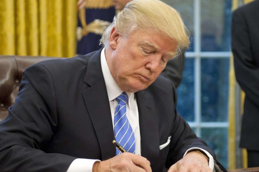President Donald Trump signs an executive order pulling the US out of the Trans-Pacific Partnership trade pact. Photo: EPA