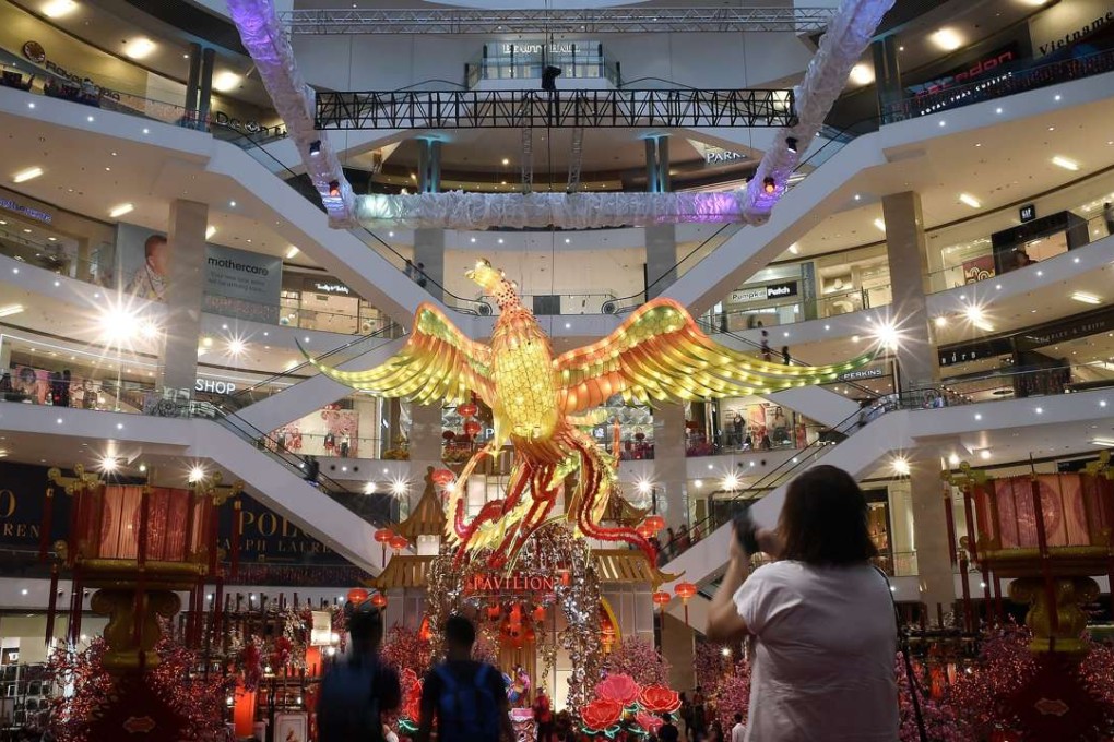 Visitors walk past a giant rooster installation as part of upcoming Lunar New Year celebrations at a shopping mall in Kuala Lumpur. Photo: AFP