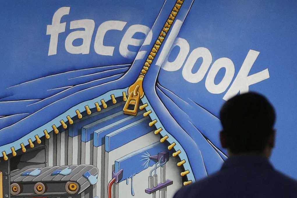 A Facebook employee walks past a sign at Facebook headquarters in Menlo Park, California. Photo: AP