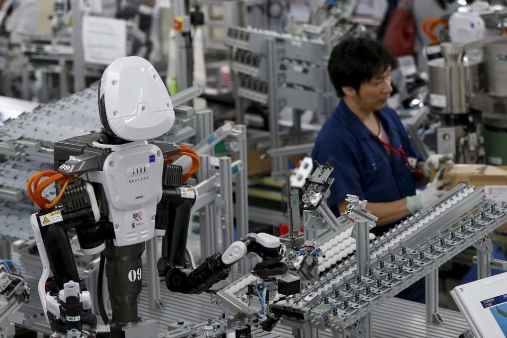 A humanoid robot works side by side with employees on the assembly line at a factory in Kazo, north of Tokyo. Photo: Reuters