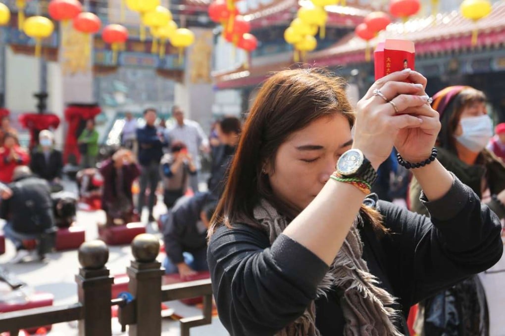 Worshippers pray for the selection of their fortune sticks at Wong Tai Sin. Photo: Xiaomei Chen