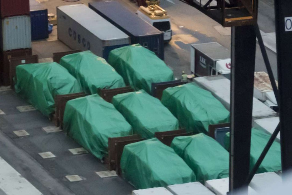 Nine Singapore-made Terrex armoured troop carriers lie under tarpaulin last November 24, after being seized at the Kwai Tsing container terminals the previous day while in transit from military exercises in Taiwan. Photo: AP