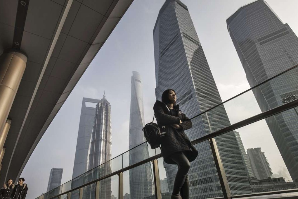 A file picture of a woman walking past skyscrapers in Shanghai’s Pudong district. Photo: Bloomberg