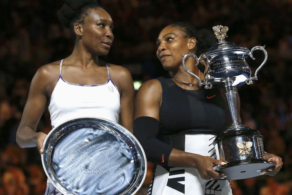Serena Williams (right) holds her trophy after beating sister Venus. Photos: Reuters