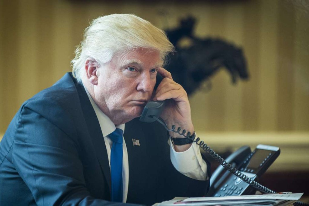 US President Donald Trump speaks on the phone with Vladimir Putin, Russia's president, during the first official phone talks in the Oval Office of the White House in Washington, DC. Photo: Bloomberg