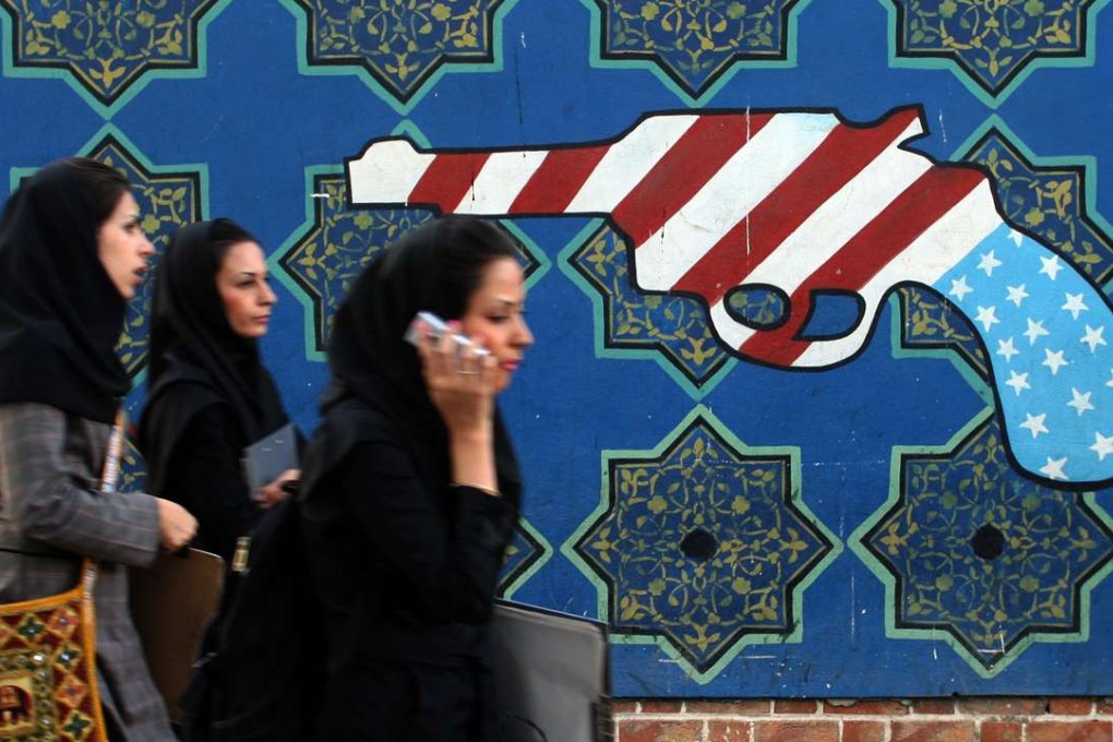 Iranian students walk past an anti-US mural on the wall of the former US embassy in Tehran. Iran is one of the seven Muslim-majority countries affected by the US entry bans. Photo: AFP
