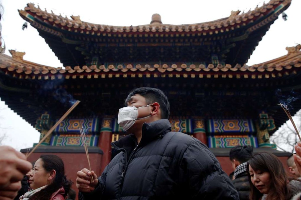 Grey skies hang over Lunar New Year revellers at the Yonghegong Lama Temple in Beijing on Saturday. Photo: Reuters