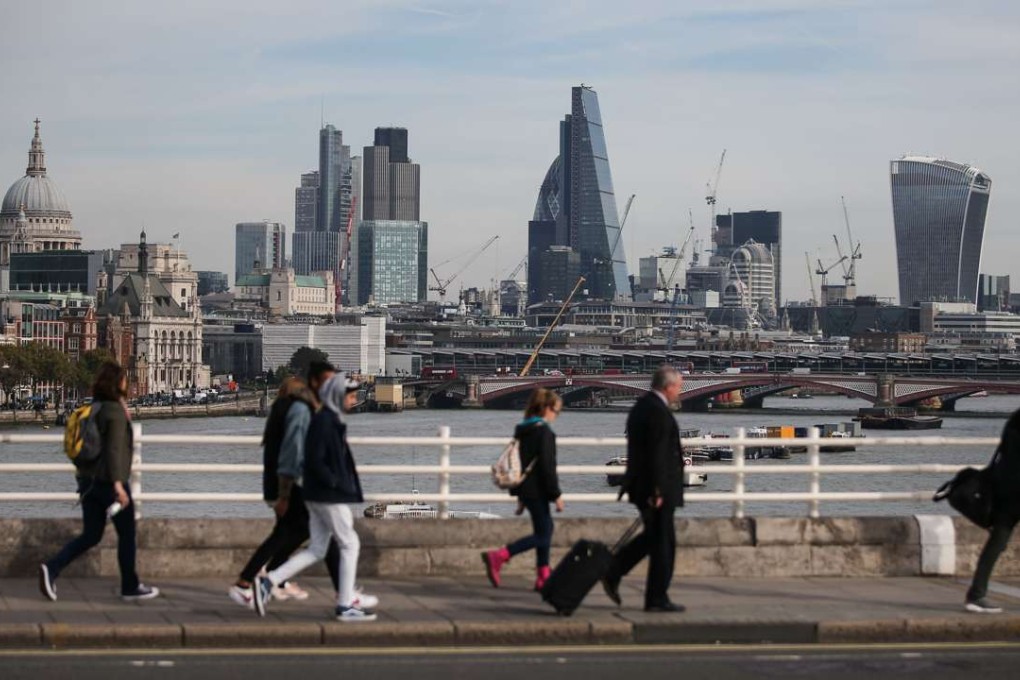 Pedestrians walk across Waterloo Bridge with a view of Central London in the background. Photo: AFP