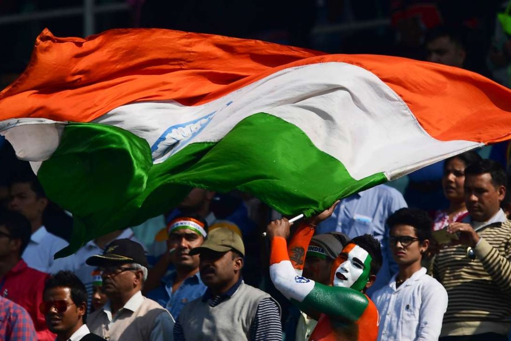 An Indian cricket fan waves the national flag during the third One Day International match between India and England at the Eden Gardens Cricket Stadium in Kolkata. Photo: AFP