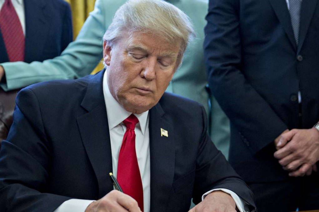 US President Donald Trump signs an executive order. Photo: Bloomberg