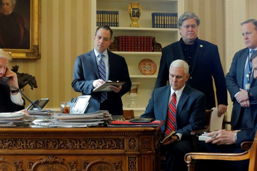 US President Donald Trump speaks on the phone with Russian President Vladimir Putin in the Oval Office, watched by his White House inner circle (left to right), Chief of Staff Reince Priebus, Vice-President Mike Pence, Chief Strategist Steve Bannon, Communications Director Sean Spicer and National Security Adviser Michael Flynn, on January 28. Photo: Reuters