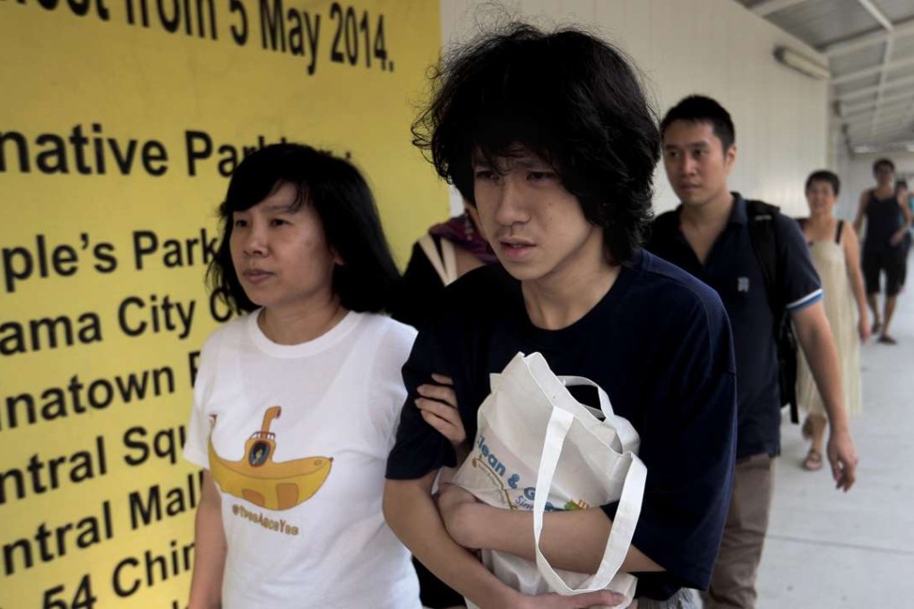 A July 2015 picture of teenage blogger Amos Yee (centre) and his mother Mary Toh. Photo: EPA
