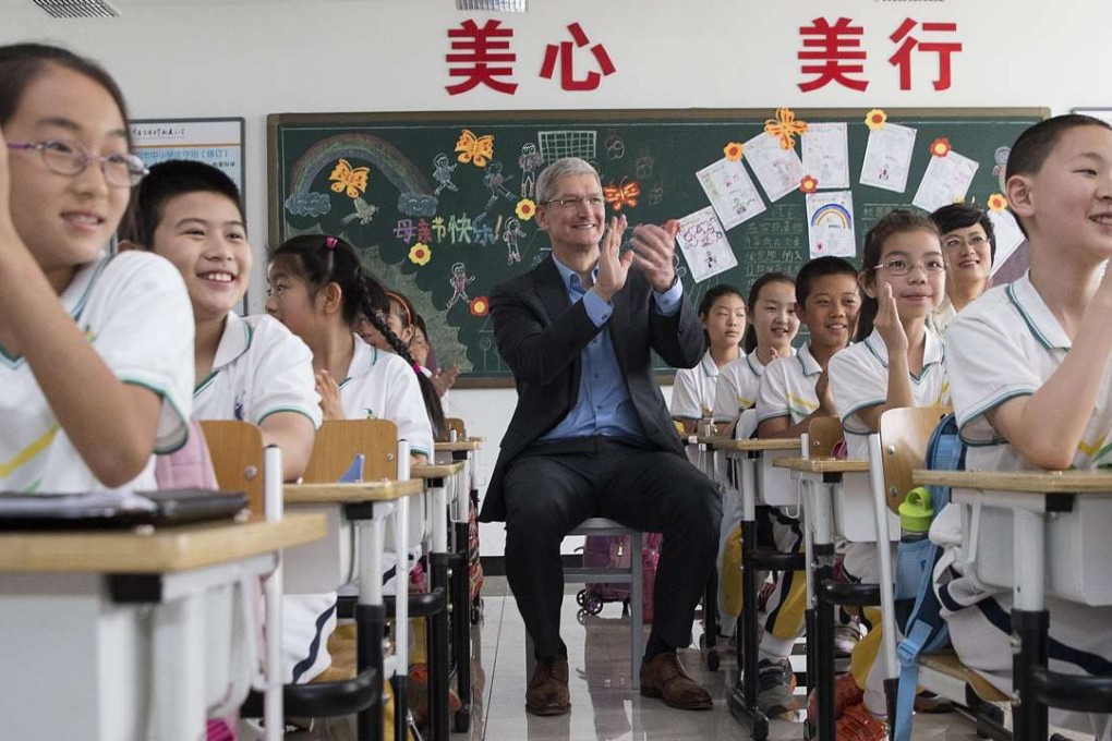 Apple CEO Tim Cook takes part in lessons at a primary school affiliated with the Communication University of China to observe how pupils use the iPad to learn English. Photo: Xinhua