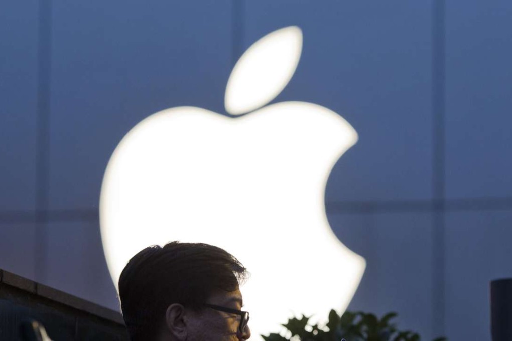 A man uses his mobile phone near an Apple store in Beijing, China. Photo: AP