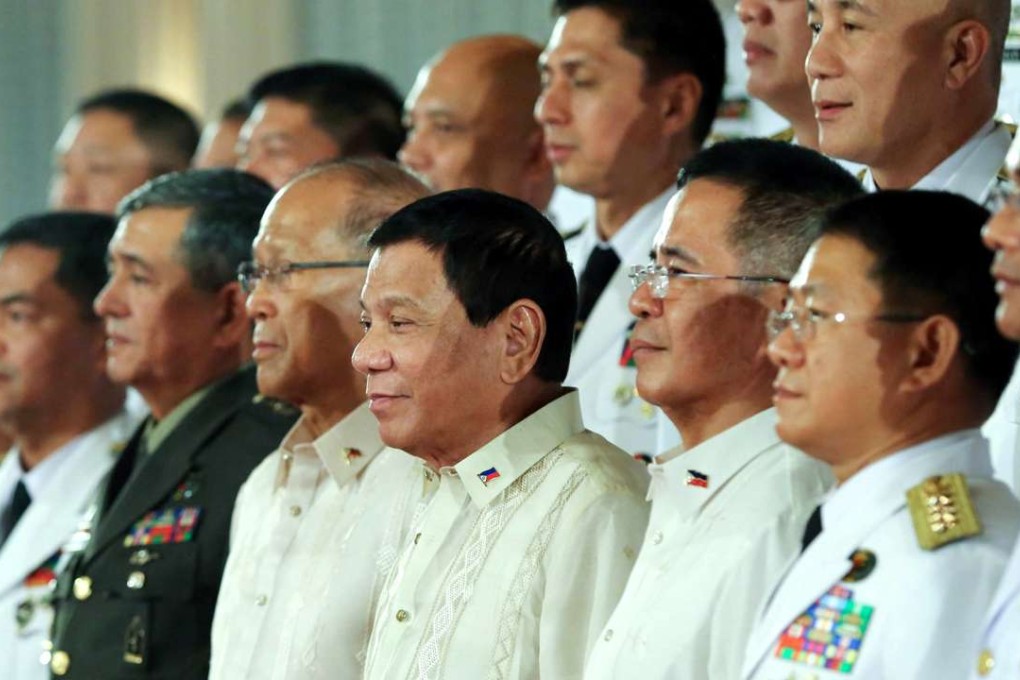 A handout photo made available by the Presidential Photographers Division (PPD) shows Filipino President Rodrigo Duterte (5-R) posing for photographs with his newly promoted military generals during their oath-taking ceremony inside the Malacanang presidential palace in Manila. Photo: EPA