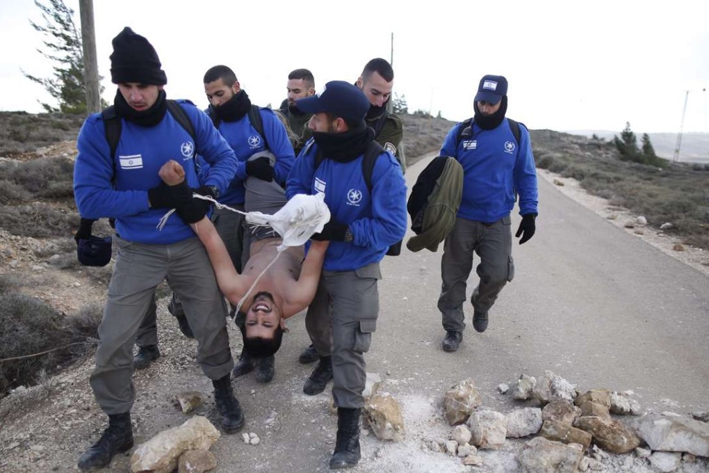 Israeli security forces arrest a settler during the evacuation of the illegal Jewish settlement of Amona. Photo: EPA