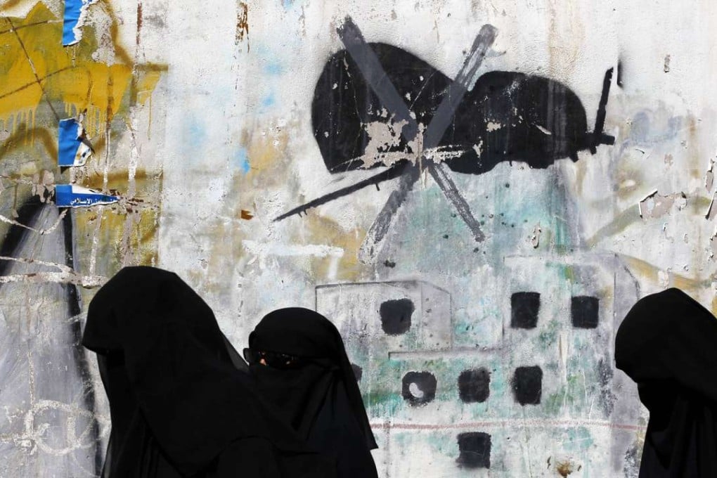 epa05759686 Yemeni women walk past a graffiti protesting US military operations in war-affected Yemen, in Sanaa. Photo: EPA