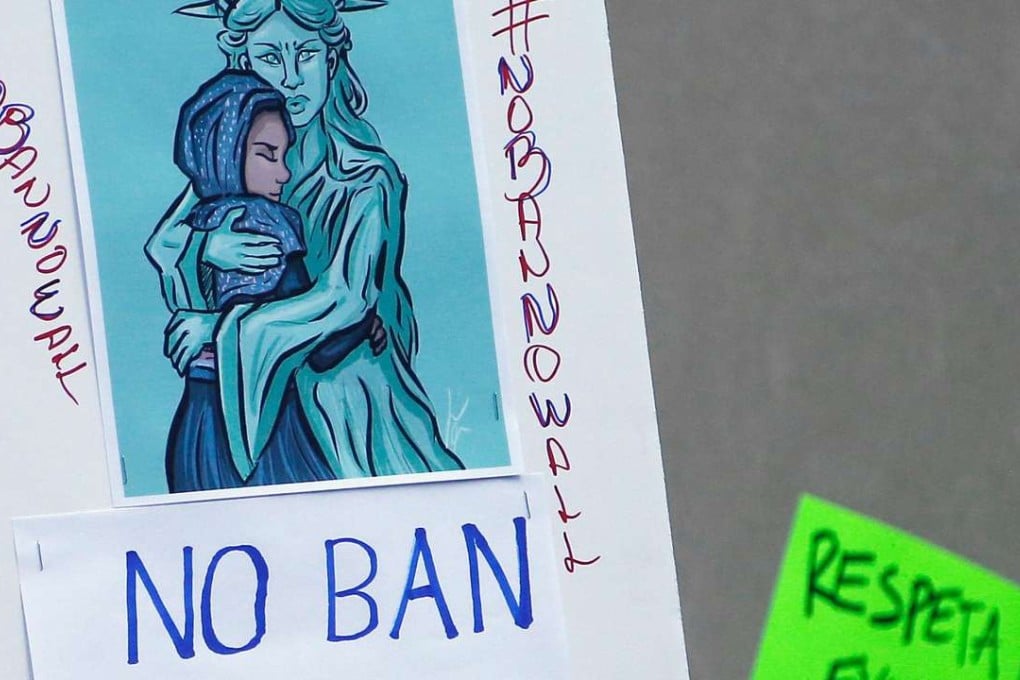 Protesters hold up signs during a rally against US President Donald Trump as resistance continued to spread inside and outside the government. Photo: AFP