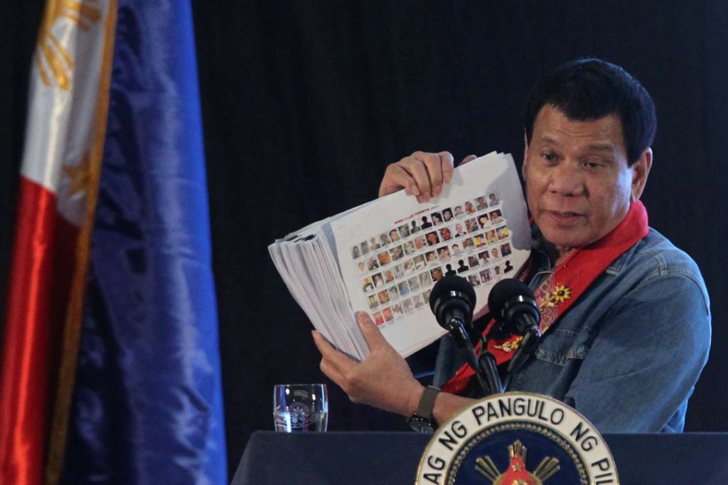 Philippine President Rodrigo Duterte holds a compilation of pictures of people involved in drugs, as he speaks during a meeting in Davao city in southern Philippines. Photo: Reuters