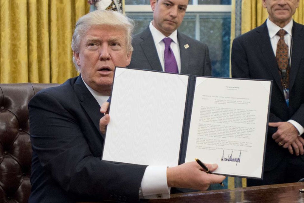 US President Donald Trump holds up an executive order withdrawing the US from the Trans-Pacific Partnership. Photo: Bloomberg