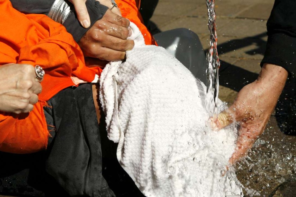 A demonstrator is held down as he voluntarily undergoes a simulation of waterboarding outside the Justice Department in Washington in this November 5, 2007 file photo. Photo: Reuters