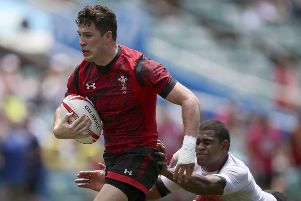 Wales' Owen Jenkins, left, runs through a tackle from Fiji's Vatemo Ravouvou to score a try. Photo: AP