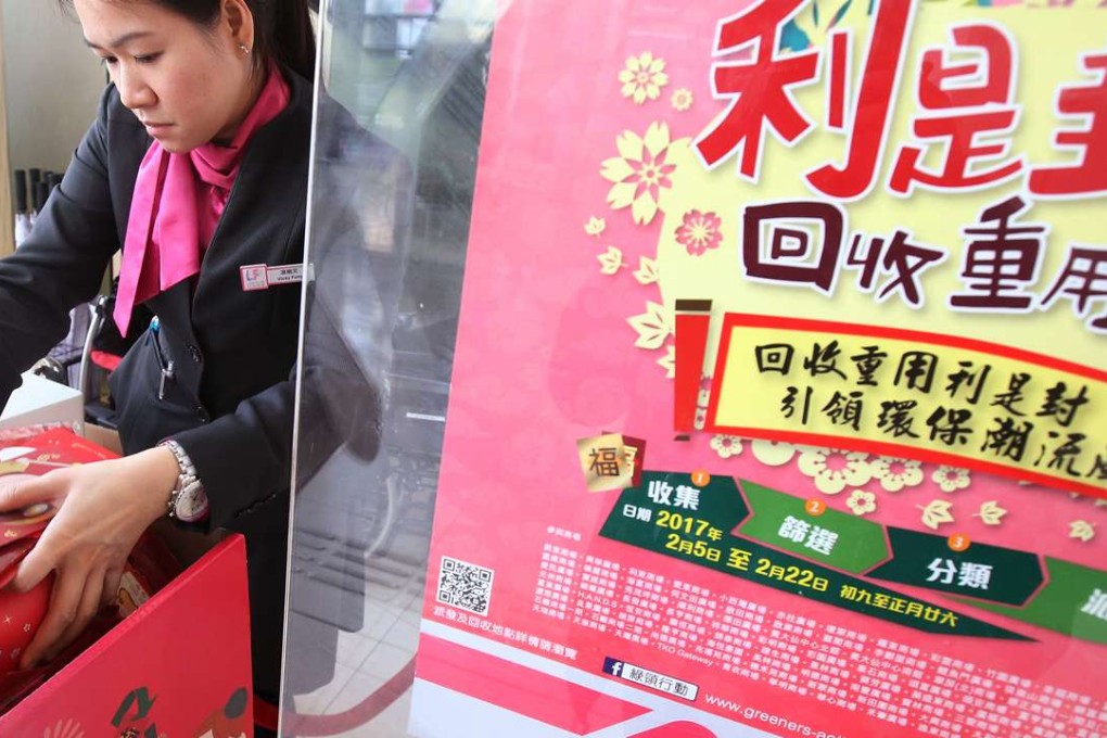 A staff member at Lok Fu Plaza sorting through red packets at a collection point set up by environmental group Greeners Action. Photo: David Wong