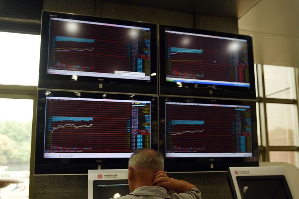 A man looks at screens showing stock market movements at a securities company in Beijing. Photo: AFP