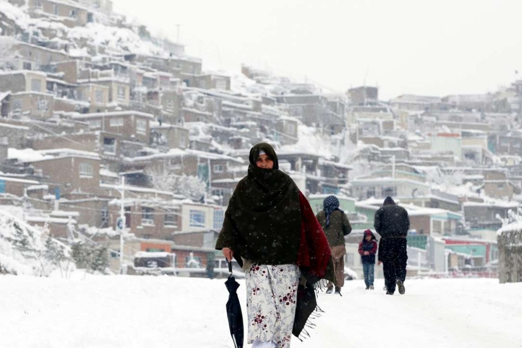 An Afghan woman walks through Kabul, where heavy snowfalls led the government to declare Sunday a public holiday. Elsewhere, the snow triggered deadly avalanches. Photo: Reuters